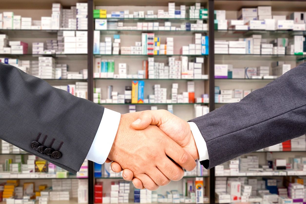 Two men shaking hands in a pharmacy.
