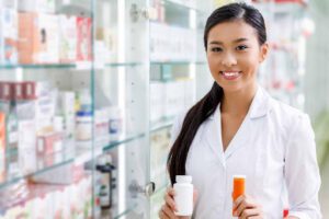 A woman standing wearing white in a medicine shop